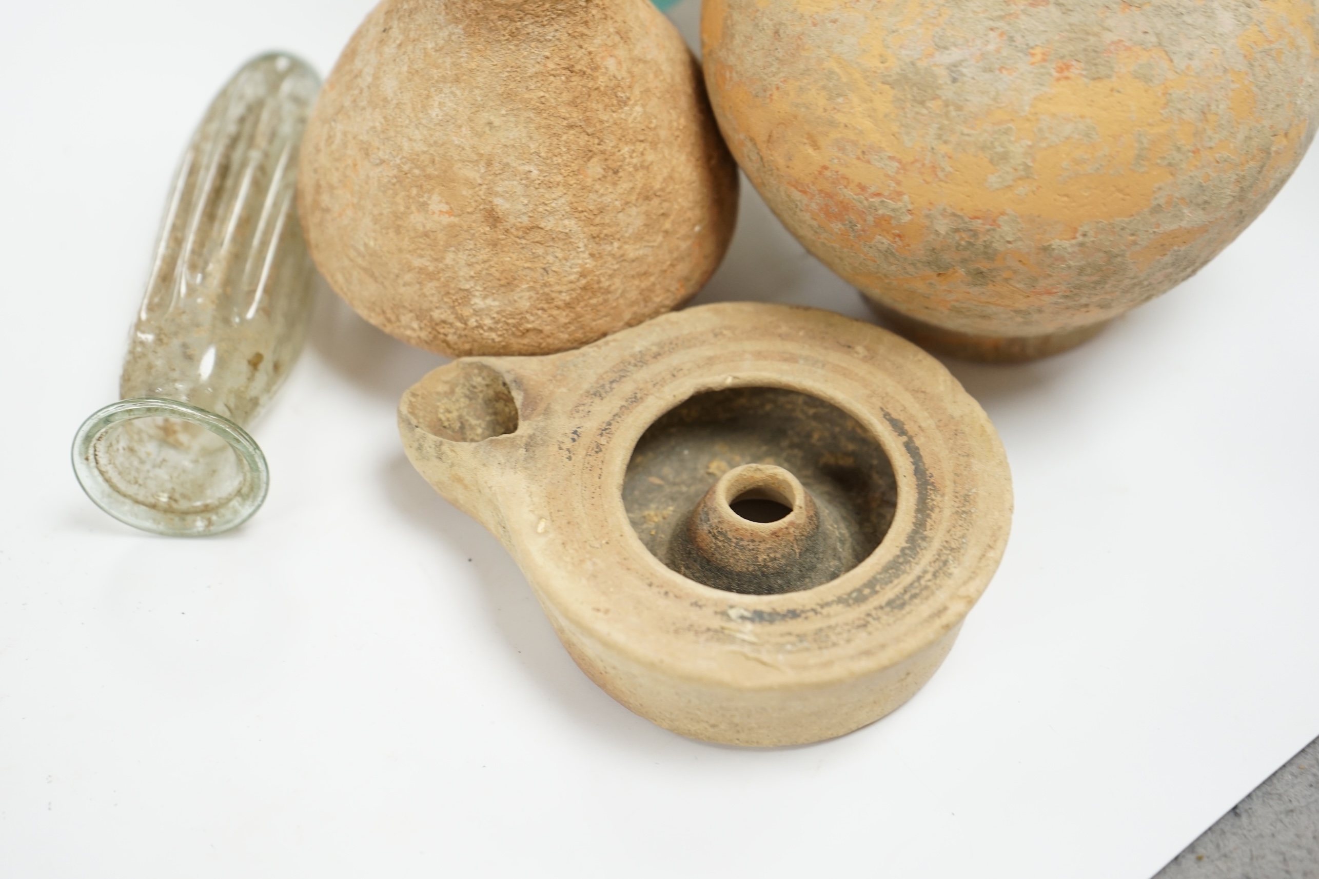 A Roman glass vase on stand, a similar Roman glass vase and three terracotta Syrian style vessels, tallest Roman vase on stand 17cm high (not including stand). Condition - Roman vase on stand cracked at neck, other vase